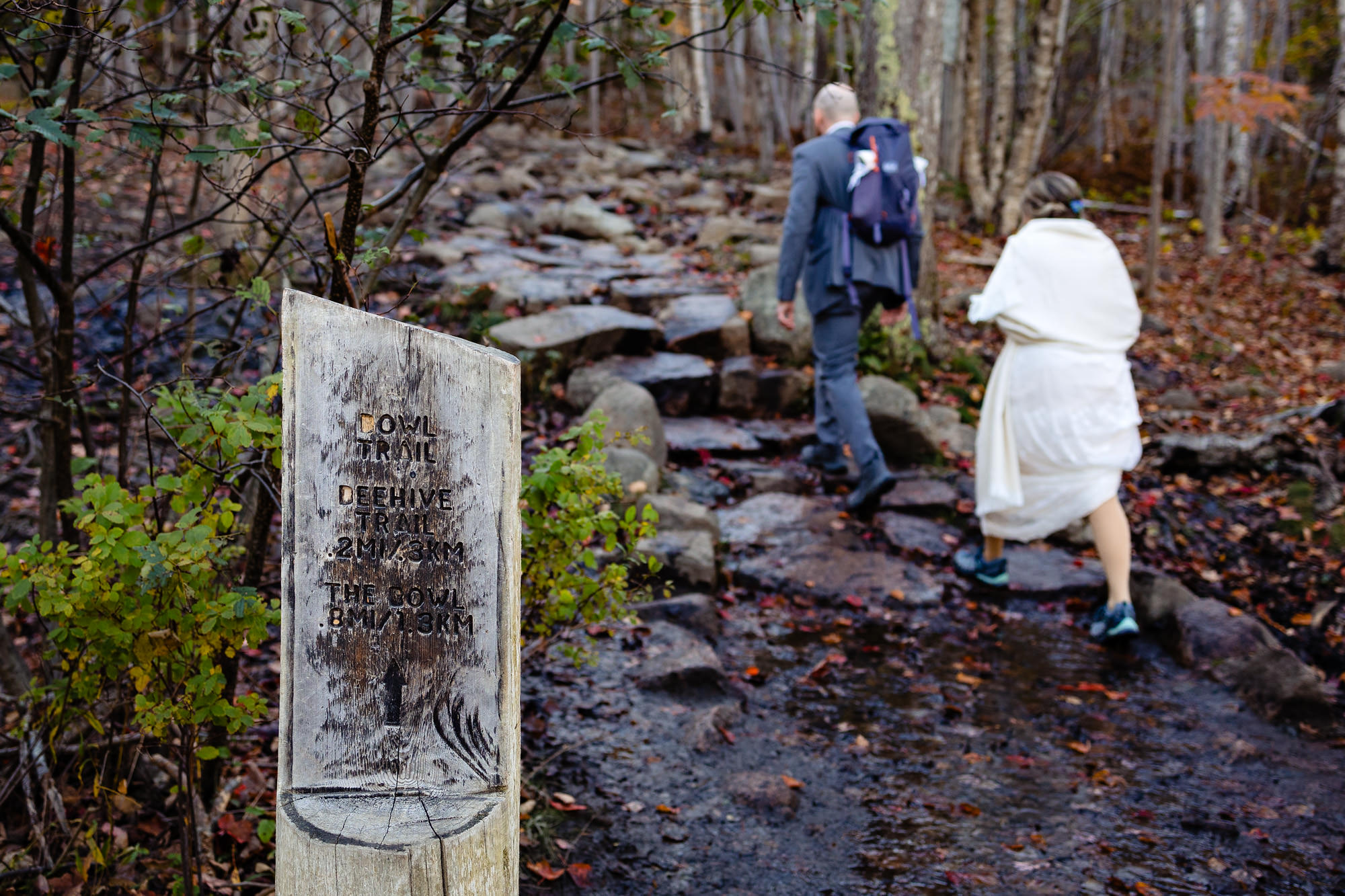 A bride and groom hike up Beehive Mountain in Acadia National Park