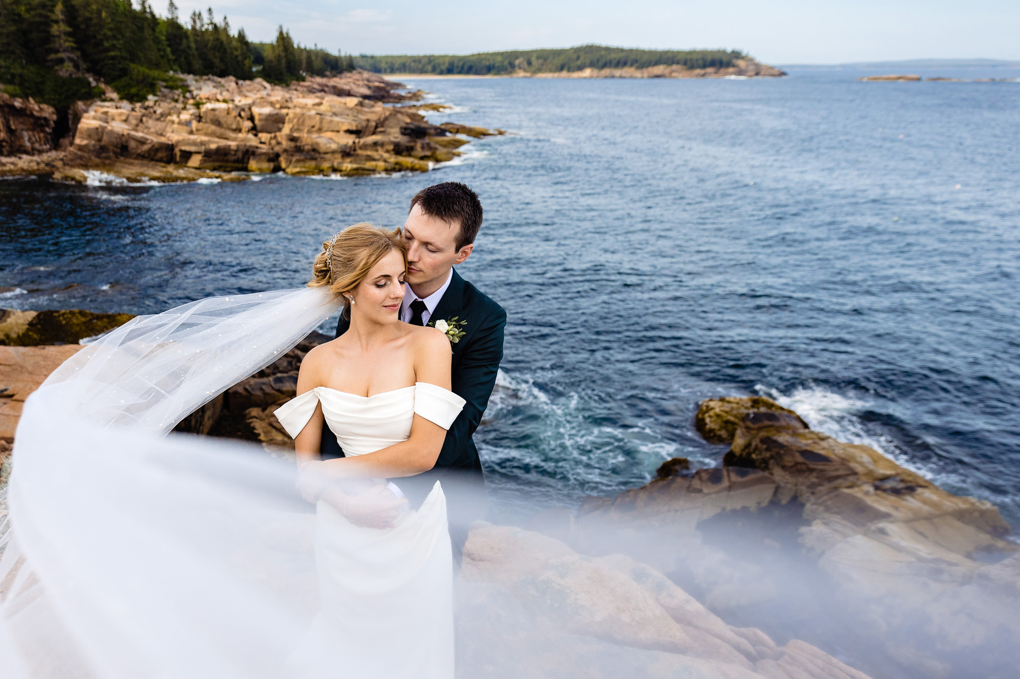 A couple embraces during wedding portraits in Acadia National Park